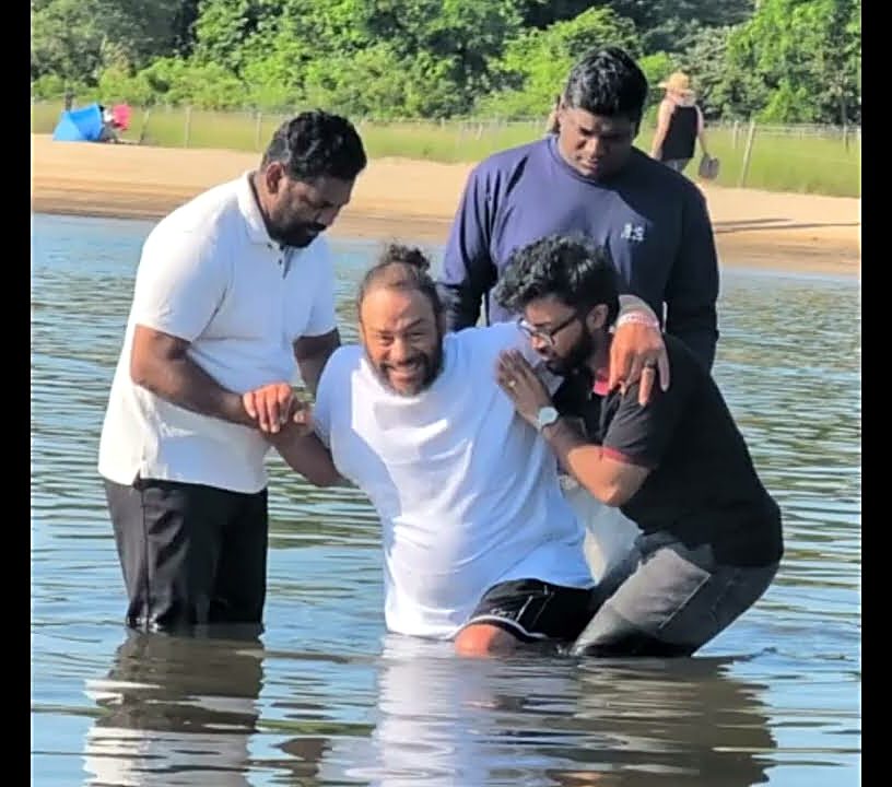 A believer being baptized in the river