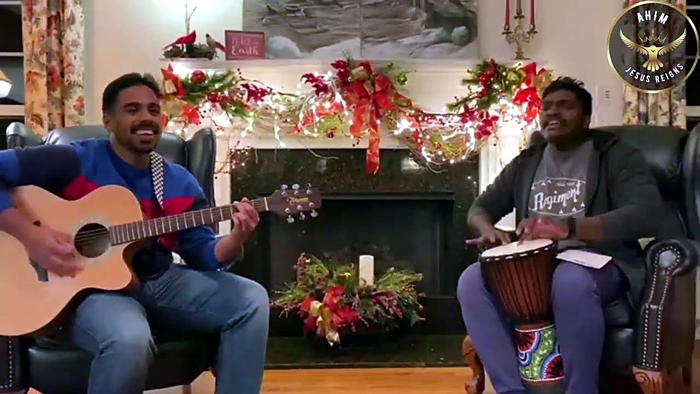 Musicians playing guitar and djembe at a Christmas worship night